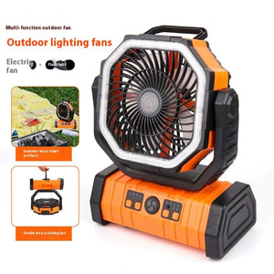  An orange and black outdoor lighting fan with "Electric fan + Flashlight" mentioned. The fan is shown on a picnic setup, illustrating its use as a summer heat relief tool. The fan can also be hung from a hook or placed on a flat surface, with an octagonal frame around the fan blades.